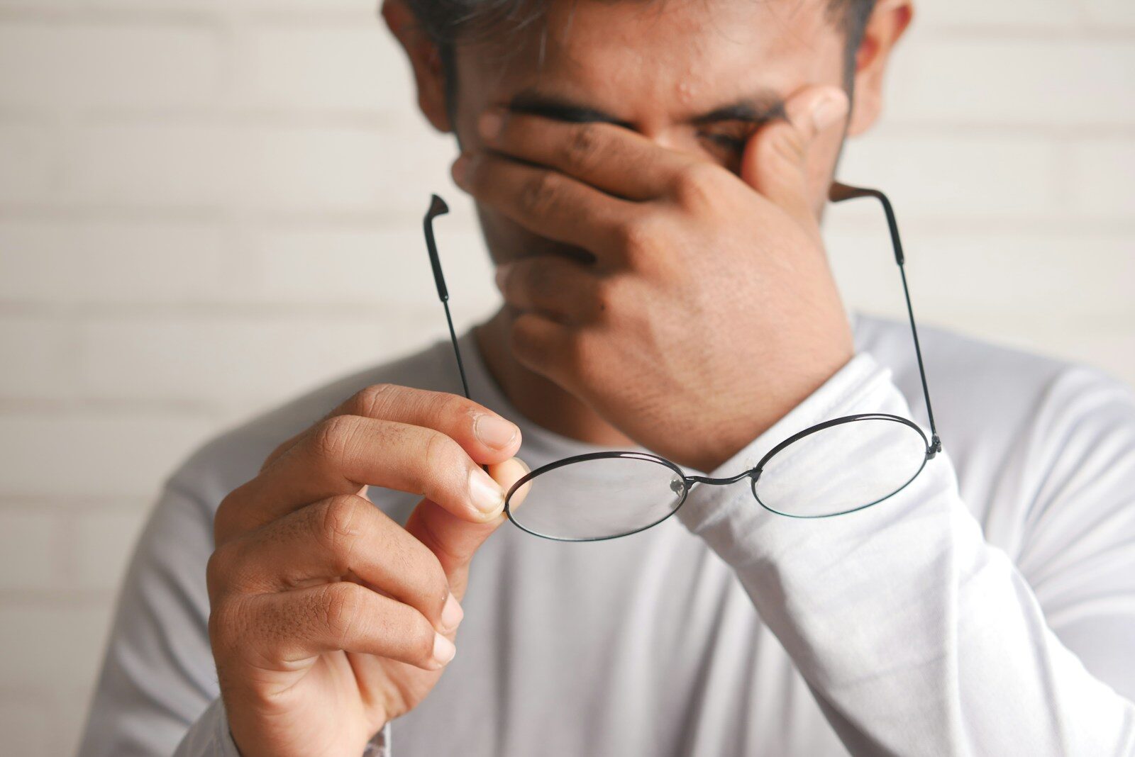 Photo by Towfiqu barbhuiya a man holding a pair of glasses up to his face
