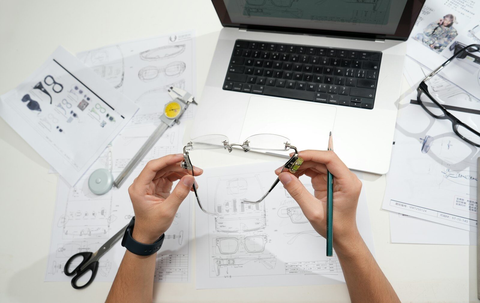Hands holding glasses over design blueprints